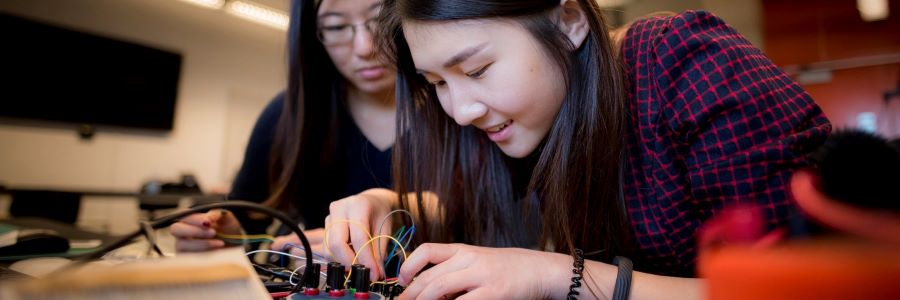 two college age females working on a circuit board