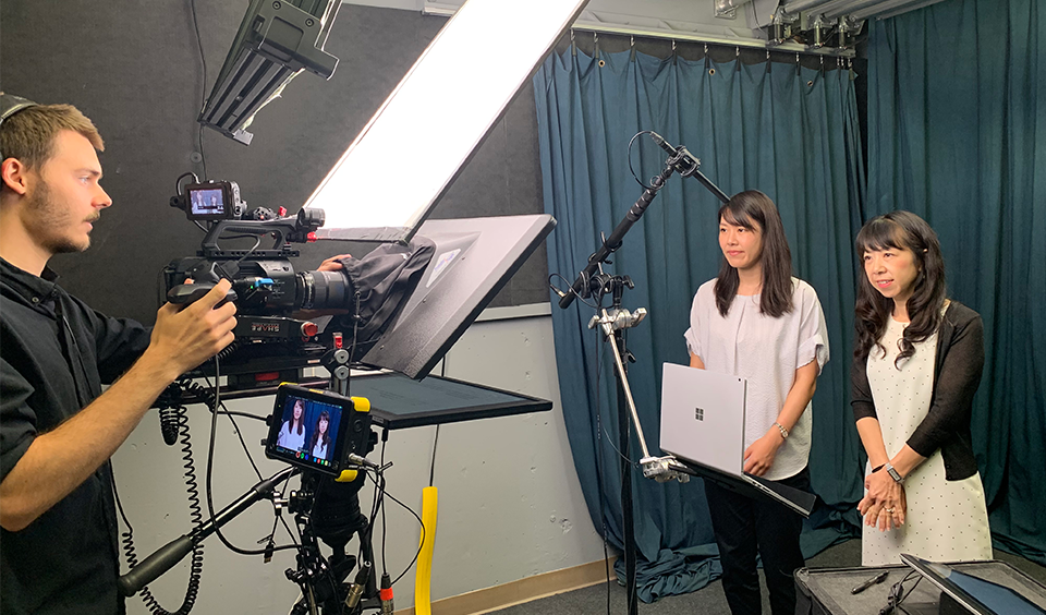 cameraman recording two females in a studio